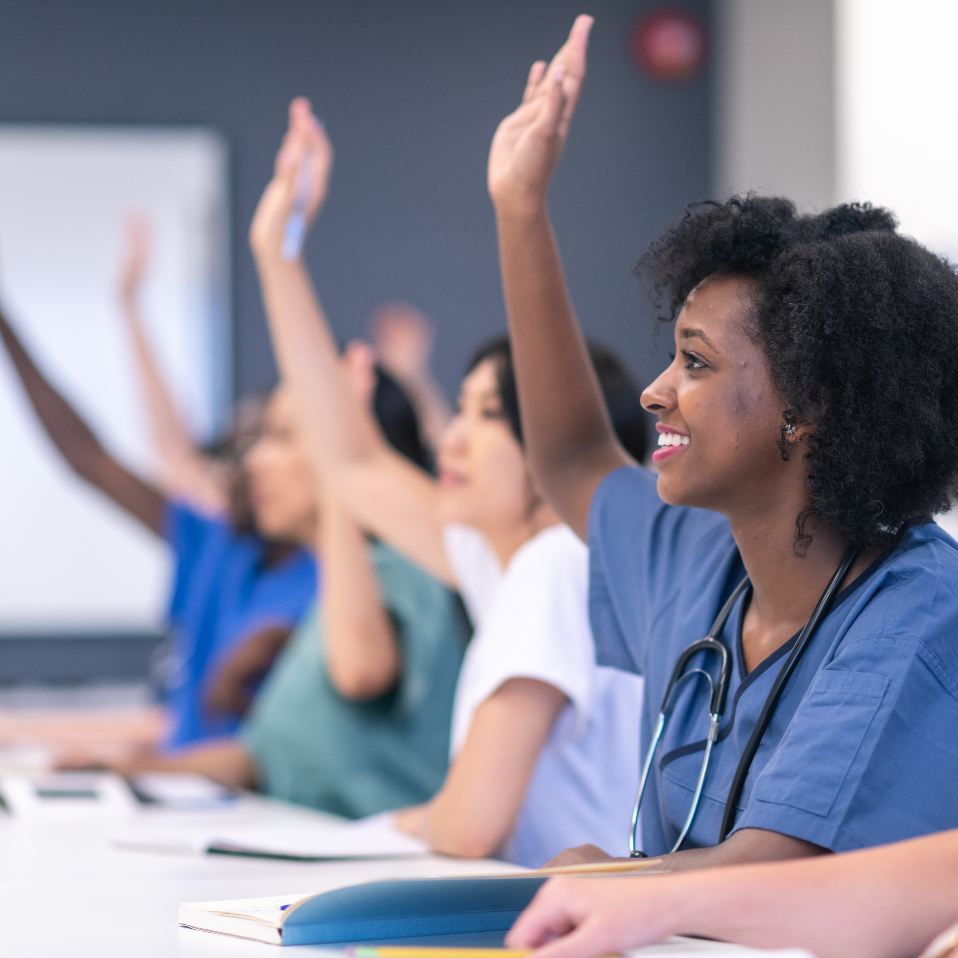 Female Doctors Raising Hands at Conference